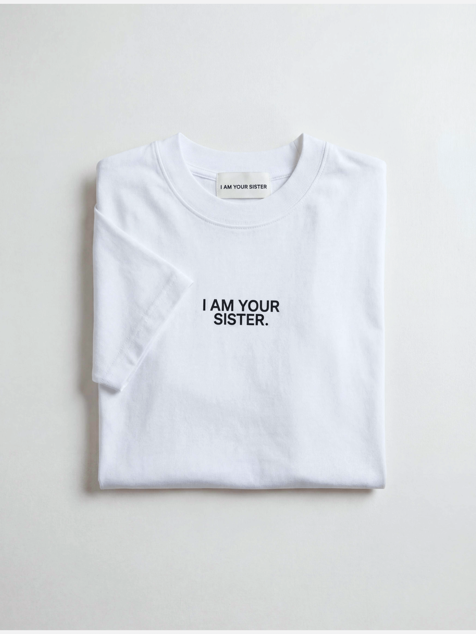 White t-shirt with 'I AM YOUR SISTER.' text on a light gray background