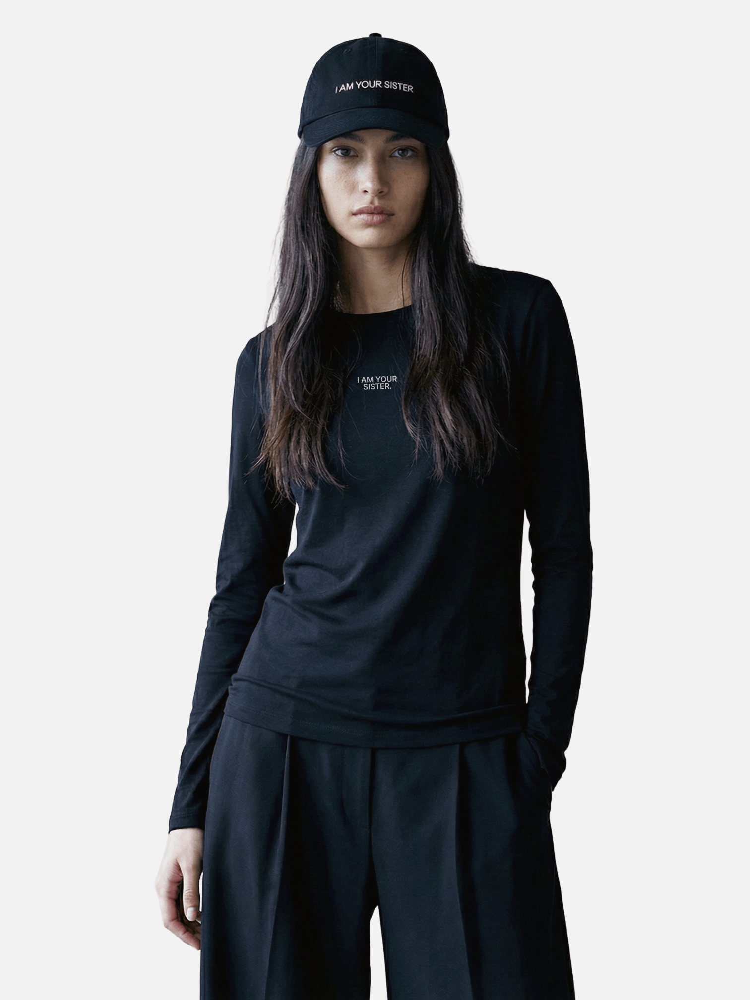 Woman wearing a black long-sleeve shirt and Sister cap with text on a white background