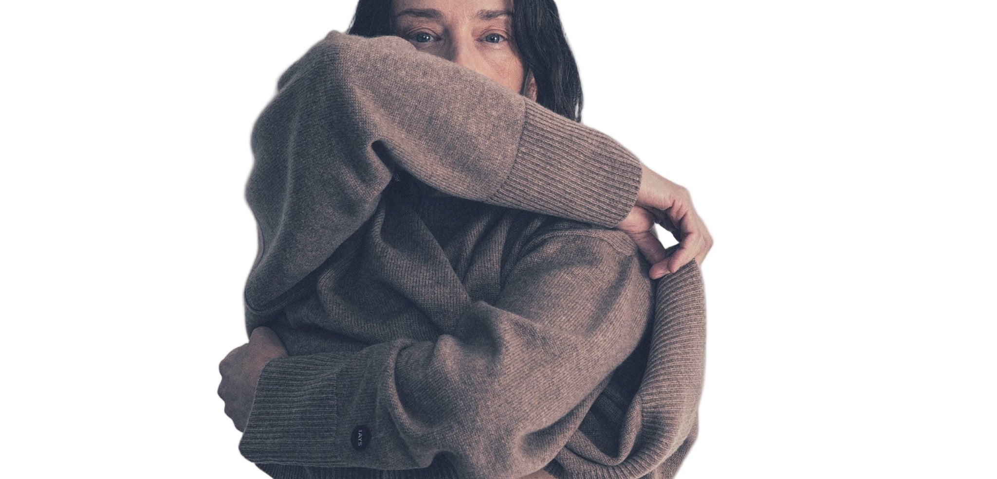 Person wearing a large brown sweater on a plain background
