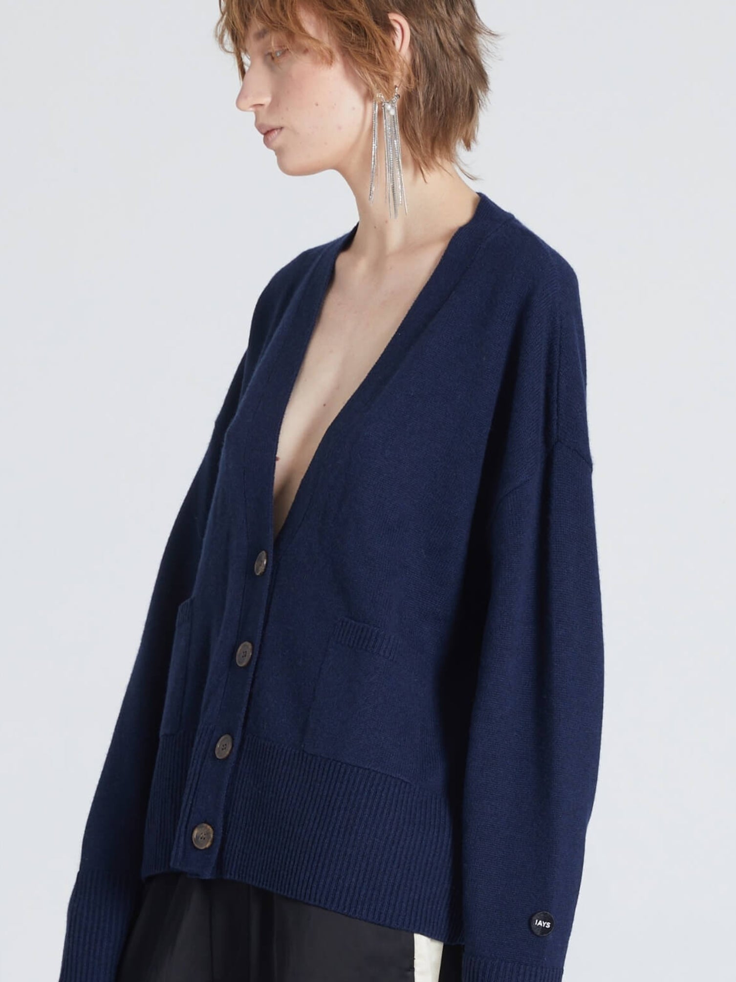 Woman wearing a navy blue cardigan on a white background